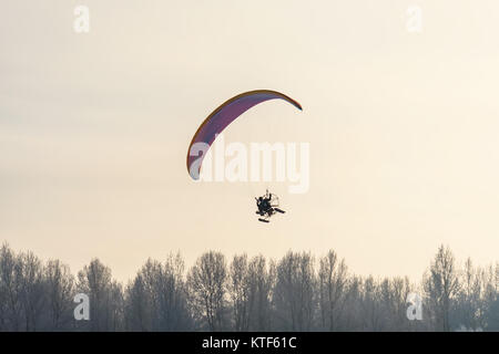 Bis in den Himmel fliegen. Gleitschirm in den Himmel mit Skiern über die Bäume. Stockfoto