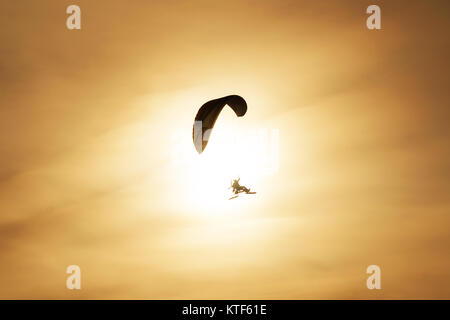 Powered paragliding Fliegen vor dem Hintergrund der untergehenden Sonne. Eine angetriebene Gleitschirm im Hintergrund sun Stockfoto