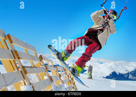 Athlet Snowboarder, Snowkiten auf dem Schnee in den Bergen Stockfoto