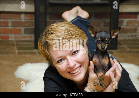 Dame mit Hund Lilly eine Tasse Tee Chihuahua/Pincher Stockfoto