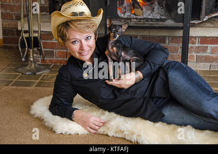 Dame mit Hund Lilly eine Tasse Tee Chihuahua/Pincher Stockfoto