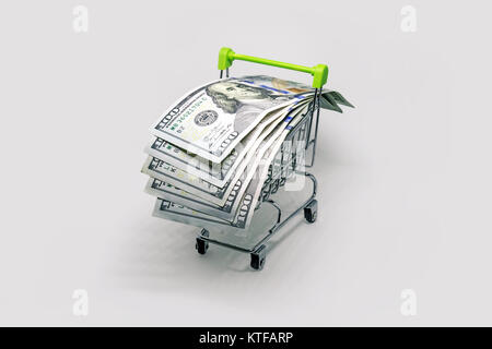 Kauf der US-Währung. close up Dollar Banknote in mini Warenkorb Spielzeug, Grün klein Warenkorb Trolley. Business und Geld gespart für Shopping Konzept. Stockfoto