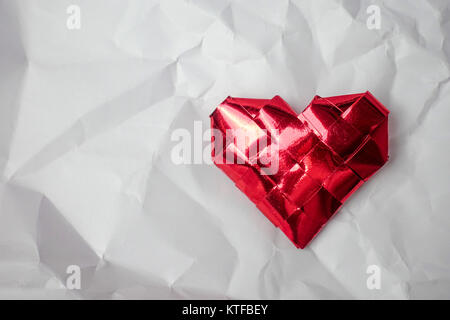 Rotes Herz auf einem weißen zerknittertes Papier Hintergrund Stockfoto
