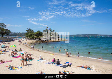 Menschen, die sich entspannen und sonnen am Balmoral Beach in Mosman, Sydney, NSW, Australien mit Rocky Point Island Stockfoto