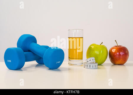 Das Konzept der gesunden Ernährung. Kleine Hanteln. Apfelsaft. Maßband Taille. Green Apple. Red Apple. auf einem weißen Hintergrund. gesunde Lebensweise. sport. Fitness Nahrung. Stockfoto