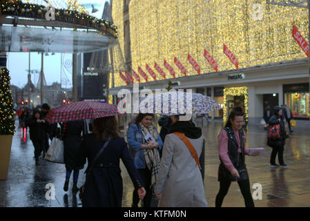 Glasgow, Schottland, Vereinigtes Königreich 24. Dezember.de Wetter: Regen und Wind grüße die Last Minute Weihnachten Käufer zu Buchanan Street, Glasgow's Stil Meile von Frasers oder die Straßen zu Princes Square Shopping Center. Kredit Gerard Fähre / alamy Nachrichten Stockfoto