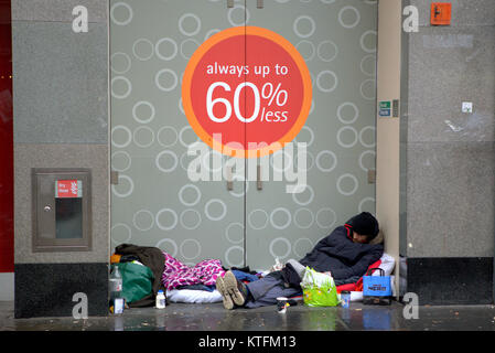 Glasgow, Schottland, Vereinigtes Königreich 24. Dezember.de Wetter: Regen und Wind grüße die Last Minute Weihnachten Käufer zu Buchanan Street, Glasgow's Stil Meile mit obdachlosen Menschen auf der Straße. Kredit Gerard Fähre / alamy Nachrichten Stockfoto