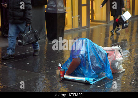 Glasgow, Schottland, Vereinigtes Königreich 24. Dezember.de Wetter: Regen und Wind grüße die Last Minute Weihnachten Käufer zu Buchanan Street, Glasgow's Stil Meile mit obdachlosen Menschen auf der Straße. Kredit Gerard Fähre / alamy Nachrichten Stockfoto