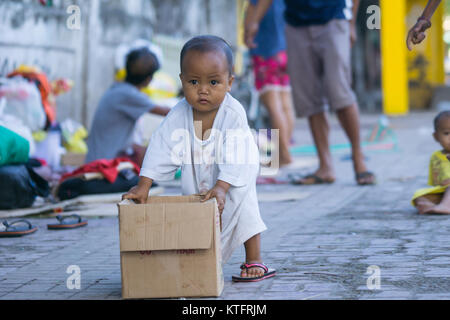 Cebu City, Philippinen. 25 Dez, 2017. Ein heimatloses Kind drückt einen Karton am Weihnachtstag morgen 2017, Cebu City, Philippinen Quelle: bildergallerie 2/Alamy leben Nachrichten Stockfoto