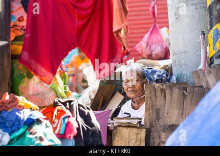 Cebu City, Philippinen. 25 Dez, 2017. Eine alte Frau schaut aus ihrem Haus aus Kartons und andere Abfälle an Weihnachten Morgen 2017, Cebu City, Philippinen Quelle: bildergallerie 2/Alamy leben Nachrichten Stockfoto