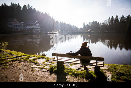 Kaisersbach, Deutschland. 25 Dez, 2017. Eine junge Frau neben Ebnisee See in der Nähe von Kaisersbach, Deutschland, 25. Dezember 2017. Credit: Christoph Schmidt/dpa/Alamy leben Nachrichten Stockfoto