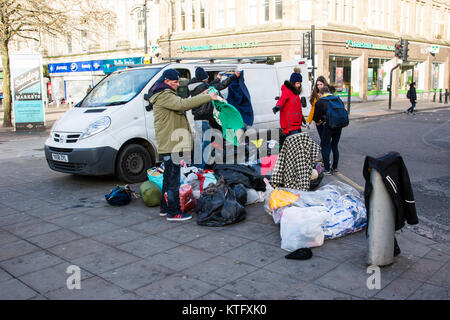 Manchester UK; 25. Dezember 2017: Manchester Rough Sleepers in Manchester am Weihnachtstag. Eine Mutter und eine Tochter mit einem Lieferwagen voller Kleider, die Sie der Obdachlosen Rough Sleepers im Stadtzentrum von Manchester versammelt sind. Kerben der Obdachlosen Rough Sleepers verbringen ihr Weihnachten kauerte im shop Türen. Mehrere Passanten angehalten, mit Ihnen zu sprechen, einige mit Kaffee und Essen von den nahe gelegenen Filialen von Starbucks, während eine Mutter und Tochter ihre van im Piccadilly geparkt, die Kleidung zu den Obdachlosen von hinten ihre van Hand. Credit: Dave Ellison/Alamy leben Nachrichten Stockfoto