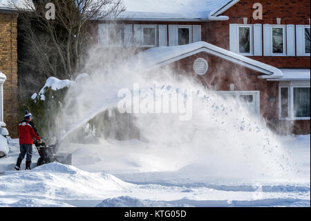 Oakville, Ontario, Kanada am 25. Dezember 2017. Der Mann mit der schneefräse Reinigung einer Einfahrt nach Weihnachten Morgen Schneesturm Credit: Elena Korchenko/Alamy leben Nachrichten Stockfoto