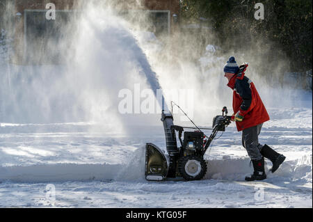 Oakville, Ontario, Kanada am 25. Dezember 2017. Der Mann mit der schneefräse Reinigung einer Einfahrt nach Weihnachten Morgen Schneesturm Credit: Elena Korchenko/Alamy leben Nachrichten Stockfoto