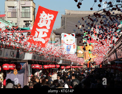 Tokio, Japan. 26 Dez, 2017. Große Holzplatte mit einem Maneki Neko - oder Beckoning Cat und Glücksbringer Gegenstände über der Asakusa Nakamise Street für den Ansatz der Sensoji-tempel mit Jahresende Shopper und Touristen überfüllt, die bevorstehende eine neue Im in Tokio am Dienstag zu feiern angezeigt, 26. Dezember 2017. Viele der japanischen Menschen Shinto-Schreine und buddhistische Tempel für das Neue Jahr Gebete besuchen. Credit: Yoshio Tsunoda/LBA/Alamy leben Nachrichten Stockfoto