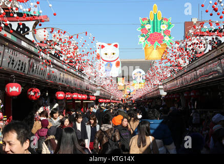 Tokio, Japan. 26 Dez, 2017. Große Holzplatte mit einem Maneki Neko - oder Beckoning Cat und Glücksbringer Gegenstände über der Asakusa Nakamise Street für den Ansatz der Sensoji-tempel mit Jahresende Shopper und Touristen überfüllt, die bevorstehende eine neue Im in Tokio am Dienstag zu feiern angezeigt, 26. Dezember 2017. Viele der japanischen Menschen Shinto-Schreine und buddhistische Tempel für das Neue Jahr Gebete besuchen. Credit: Yoshio Tsunoda/LBA/Alamy leben Nachrichten Stockfoto