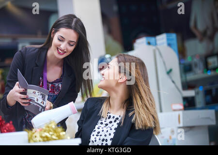 Haircare. Schöne lange behaarte Frau trocknen Haar in elektronischen Speichern Stockfoto