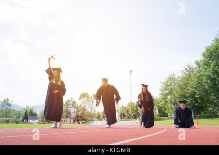 Bildung, Graduierung und Personen Konzept - Gruppe von Happy internationale Studierende in Mörtel Boards und Bachelor- Kleider mit den Diplomen Stockfoto