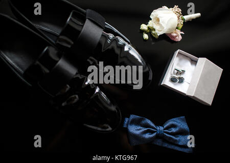 Nahaufnahme des modernen Menschen Zubehör. Blaue fliege, schwarze Schuhe, Anstecker und Manschettenknöpfe. Stockfoto