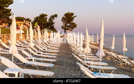 Die Sonnenliegen am Strand in einer Reihe einsatzbereit Stockfoto