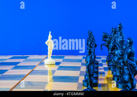 Schach auf schwarzen Hintergrund. White pawn ist mit Blick auf die feindliche Armee Stockfoto