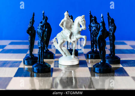 Schach auf schwarzen Hintergrund. Eine hölzerne Schach horse steht umgeben von Bauern Stockfoto