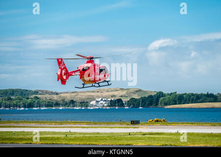 OBAN/SCHOTTLAND - 17 Mai 2017: Red Air Ambulance Hubschrauber starten zurück nach Irland zu fliegen Stockfoto