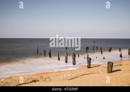 Äußere tagsüber lange Belichtung Foto von hölzernen Masten steigen von Sand auf Cape May, New Jersey Strand in Cape May County auf Delaware Bay Stockfoto