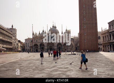 Am frühen Morgen Bild von der Piazza San Marco mit ein paar Menschen zu Fuß in Venedig. Saint Mark's Basilika und Campanile di San Marco (aus dem 16. Jahrhundert Platz cat Stockfoto