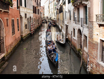 Touristen fahren Gondeln Tour auf Kanälen zwischen alten, historischen Gebäuden in Venedig/Italien. Stockfoto