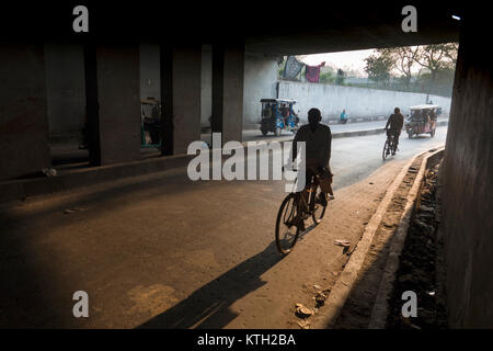 Männer auf Fahrrädern ritt durch die Unterführung in Neu Delhi, Indien Stockfoto