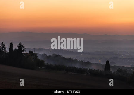 Nebel bei Sonnenuntergang füllen das Tal unter Brufa Stadt (Umbrien) Stockfoto