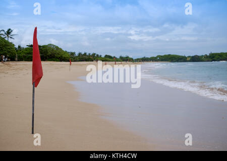 Eine rote Flagge auf dem Strand in der Nuca Dua Bali, Indonesien. Gefahr im Meer zu schwimmen. Stockfoto