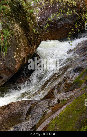 Kleine Kaskade zwischen Felsen und die natürliche Vegetation des brasilianischen Regenwaldes in Itatiaia, Rio de Janeiro Stockfoto