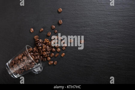 Glas Tasse Espresso und Kaffee Bohnen auf schwarzen Hintergrund, Ansicht von oben mit der Kopie Raum Stockfoto