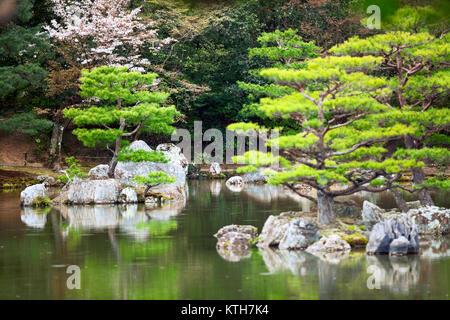 Zehn kleinere Inseln der Spiegel Teich (Kyoko-chi See) sind in herrlichen Japanischen Garten spazieren. Goldener Pavillon, Kyoto, Japan. Regentag Stockfoto