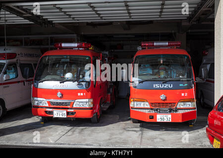 ITSUKUSHIMA, JAPAN - CA. APR, 2013: Zwei kleine Fire-Fighter Lkw stand in der Garage mit geöffneten Toren. Japanische Feuerwehr und Krankenwagen Rettungsstation ist in Stockfoto