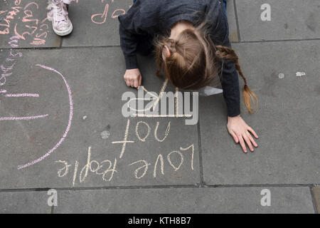 Ein Kind Demonstrant schreibt Anti-Trump und anti-Rassismus Nachricht lesen "Liebe Leute nicht Trumpf" auf dem Bürgersteig auf der UN-Anti-Rassismus Tag, London, UK. Stockfoto