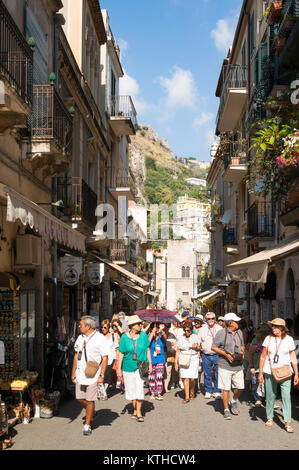 Gruppe der Touristen mit einem Reiseleiter zu Fuß durch die Altstadt von Taormina, Sizilien, Europa Stockfoto