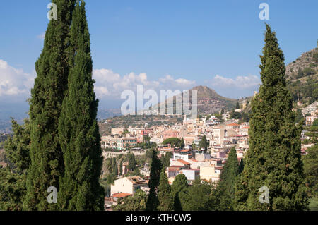 Taormina Stadtbild durch Bäume mit Berg im Hintergrund, Sizilien gesehen, Europa Stockfoto