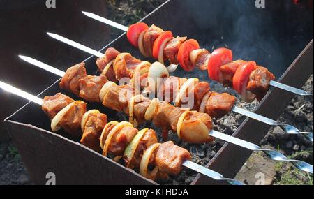 Kochen von Fleischspießen auf dem Grill. Kochen von Fleischkebab mit Gemüse. Stockfoto