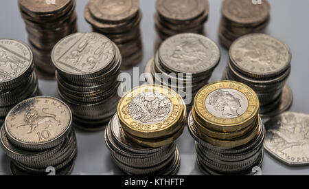 Stapel von verschiedenen britischen Münzen auf einem weißen Hintergrund. Stockfoto