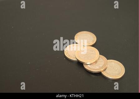 Einige Euro-Münzen und Pennies auf einem dunklen Hintergrund, den Menschen die Idee, Geld sparen in schlechten wirtschaftlichen Situationen. Achten Sie darauf, dass Sie ein Pfennig. Stockfoto