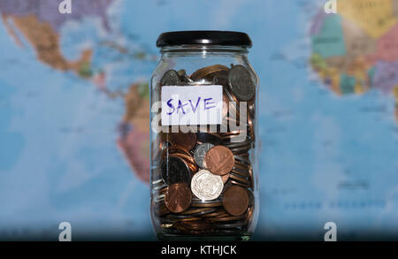 Travel Budget Konzept. Das eingesparte Geld für Urlaub in Glas Glas auf Weltkarte Hintergrund, kopieren. Münzen für große Abenteuer. Stockfoto