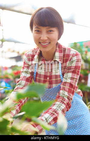 Eine schöne chinesische Frau Arbeiten in das Lächeln des Floristen an Kamera Stockfoto