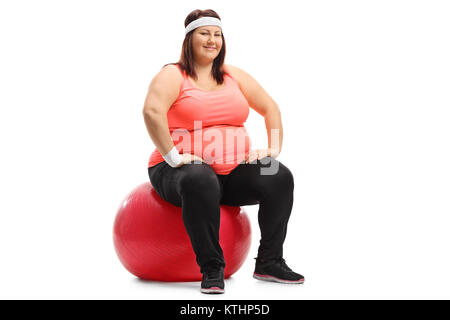 Übergewichtige Frau sitzt auf einer übung Kugel und wenn man die Kamera auf weißem Hintergrund Stockfoto