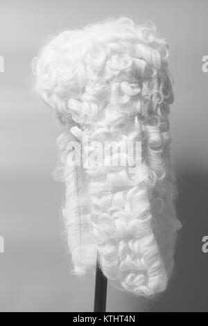 Perücke auf einem grauen Hintergrund beurteilen. Stockfoto