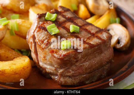 Köstliches Filet Mignon mit Kartoffeln und Pilzen close-up auf einem Teller. Horizontale Stockfoto