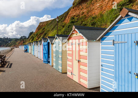 Bunten badekabinen unter den Klippen entlang der Strandpromenade in Seaton, Devon, in der Jurassic Coast, Weltkulturerbe, im Südwesten von England, Großbritannien Stockfoto