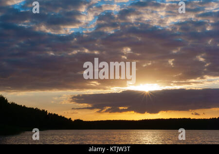 Sonnenuntergang über dem Meer. Reflexion des Sonnenlichts in den Meereswellen. Roter Himmel in den Strahlen des Sonnenuntergangs. Stockfoto